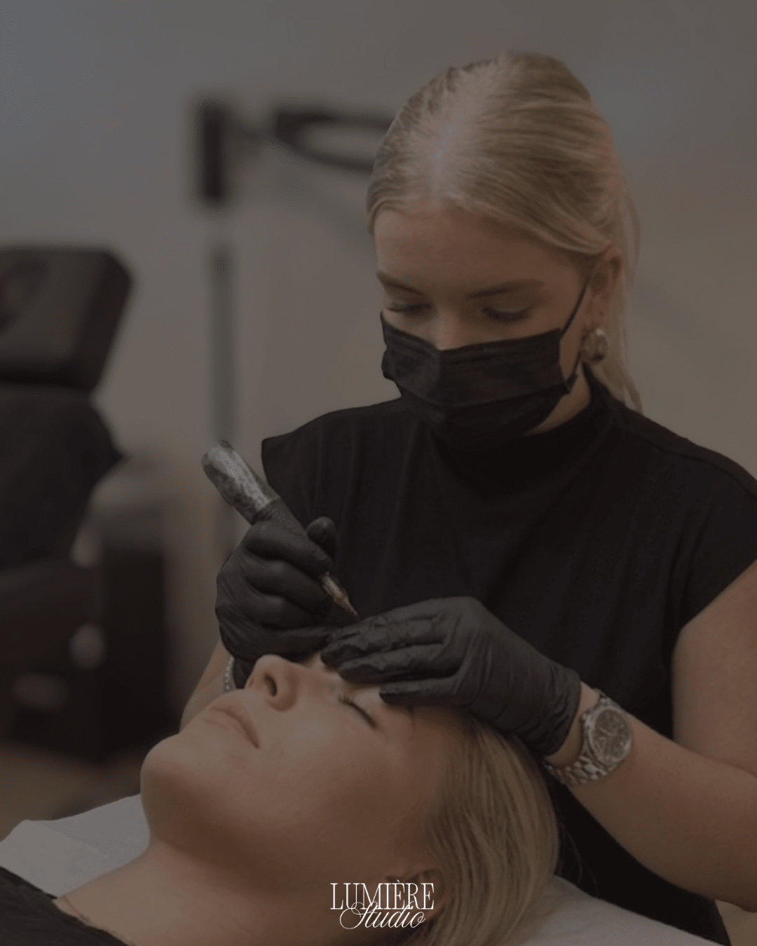 In de studio: met handschoenen en mondkapje wordt permanente make-up aangebracht bij een klant op de behandelstoel